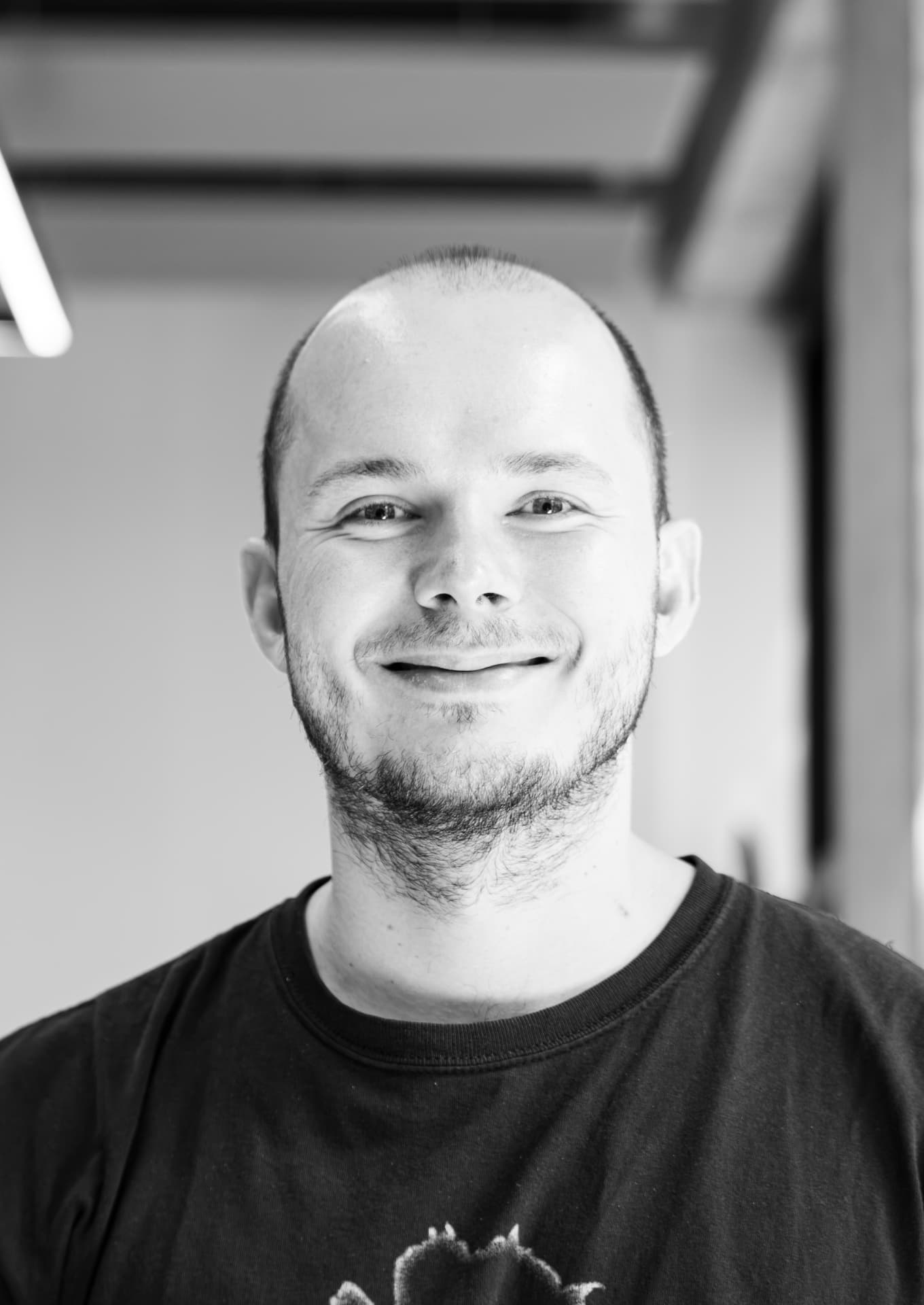 Mathias Scholtysek smiling, in a black-and-white portrait